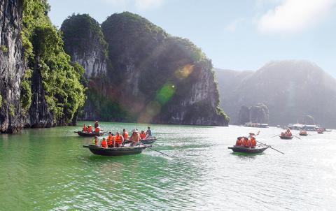 There are multiple pleasure boats at the shore heading to Ha Long Bay.