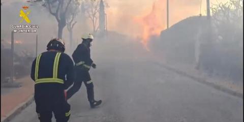 The Spanish Civil Guard checks that residents have left the vicinity of a fire near Toledo